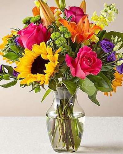 <p>The Best Day™ Bouquet is ready to create a moment your recipient will always remember! An instant mood booster with it's mix of bright bold colors, this gorgeous fresh flower arrangement brings together sunflowers, hot pink roses, purple double lisianthus, orange LA Hybrid Lilies, yellow snapdragons, green button poms, and lush greens to make this day, their best day. Presented in a clear glass vase, this fresh flower arrangement is made just for you to help you send your warmest birthday, congratulations, or get well wishes to your favorite friends and family.</p>